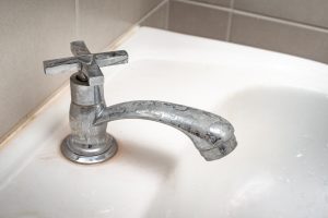 Dirty faucet with stain and limescale